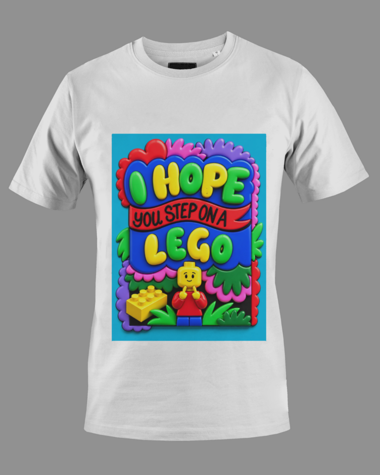 White short-sleeve t-shirt with a colorful graphic showing the phrase 'I Hope You Step on a Lego' in bold letters and a LEGO minifigure below it surrounded by colorful shapes and greenery.